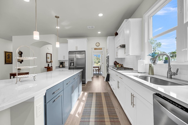 kitchen featuring appliances with stainless steel finishes, a sink, visible vents, and white cabinets