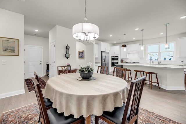 dining space with light wood finished floors, baseboards, and recessed lighting