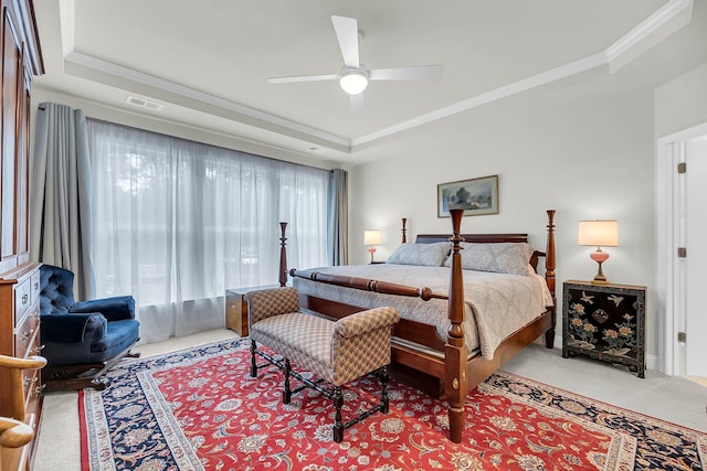 bedroom with light carpet, visible vents, a raised ceiling, and ornamental molding