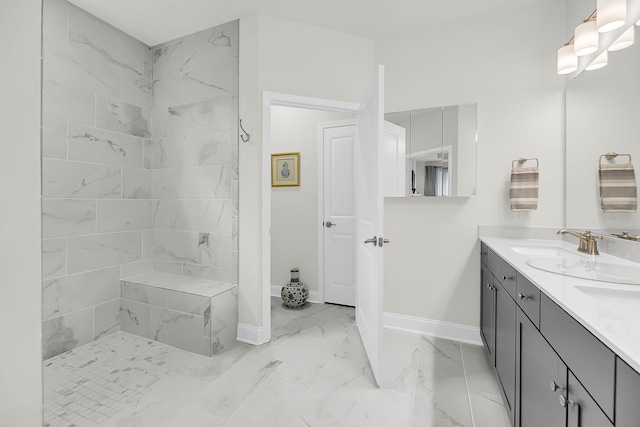 full bathroom with marble finish floor, double vanity, a sink, and baseboards