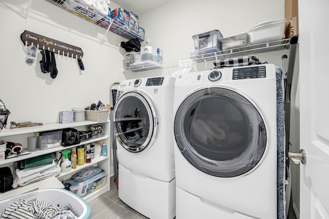 washroom featuring laundry area, light tile patterned flooring, and washing machine and clothes dryer