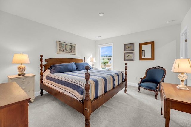 bedroom with light carpet and baseboards