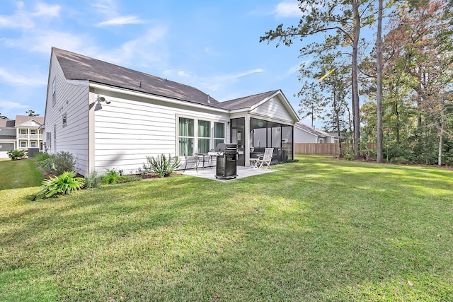 rear view of house with a yard, fence, and a patio