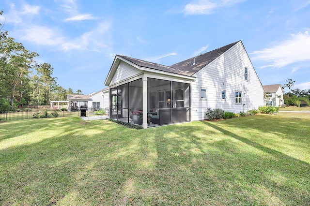 rear view of property with a sunroom, a lawn, and fence