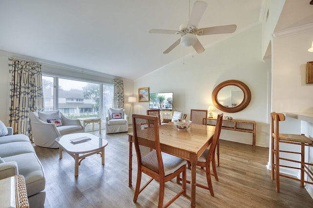 dining space with hardwood / wood-style flooring, lofted ceiling, crown molding, and ceiling fan