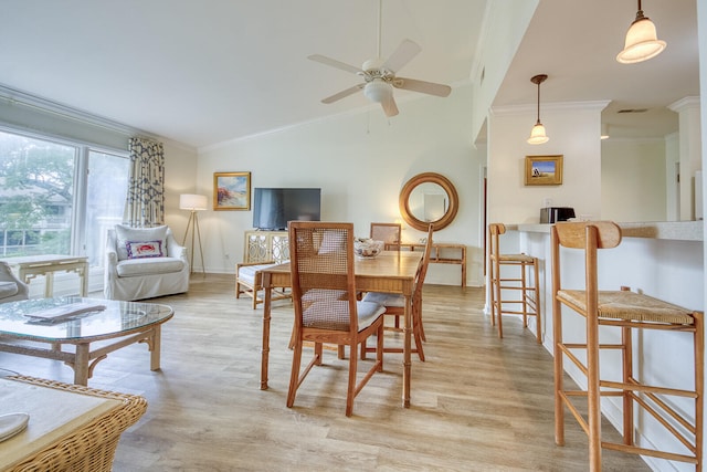 dining area featuring lofted ceiling, light hardwood / wood-style floors, crown molding, and ceiling fan