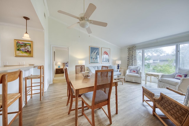 dining area featuring ceiling fan, light hardwood / wood-style flooring, lofted ceiling, and ornamental molding