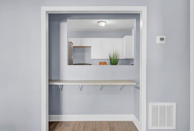 room details featuring stainless steel refrigerator and hardwood / wood-style flooring