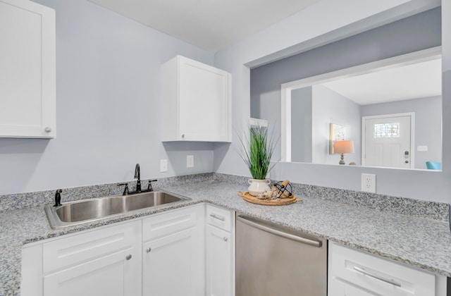 kitchen with light stone countertops, sink, white cabinetry, and dishwasher