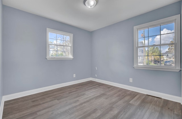 spare room with hardwood / wood-style flooring and plenty of natural light