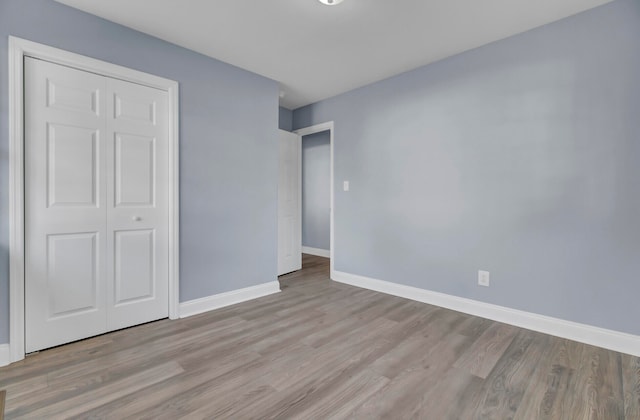 unfurnished bedroom featuring a closet and light hardwood / wood-style flooring