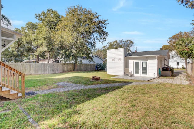 view of yard featuring an outdoor fire pit and french doors