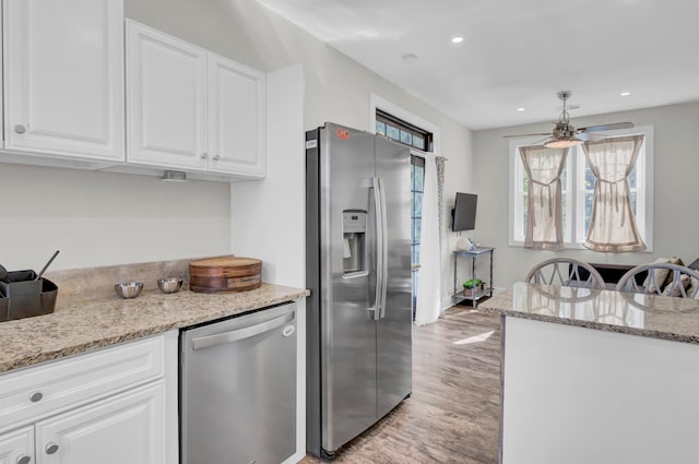 kitchen with ceiling fan, light stone countertops, white cabinets, and stainless steel appliances