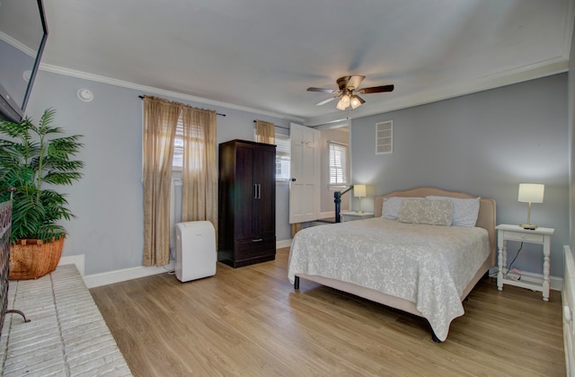 bedroom featuring light wood-type flooring, ceiling fan, and crown molding