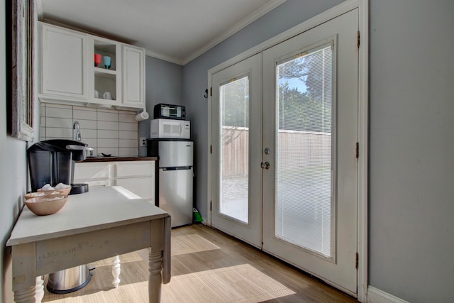 doorway featuring light hardwood / wood-style floors, crown molding, and french doors