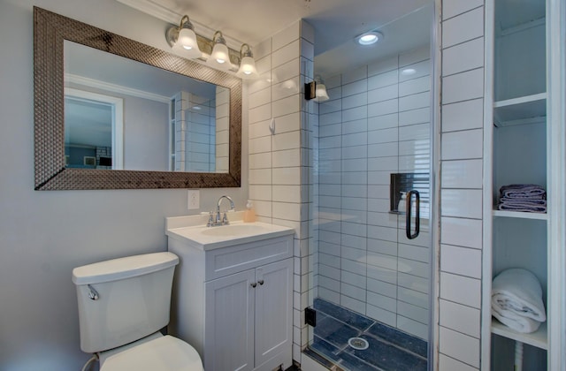 bathroom featuring toilet, vanity, a shower with door, and ornamental molding