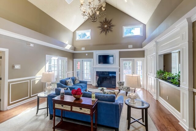 living room with high vaulted ceiling, a healthy amount of sunlight, and light wood-type flooring