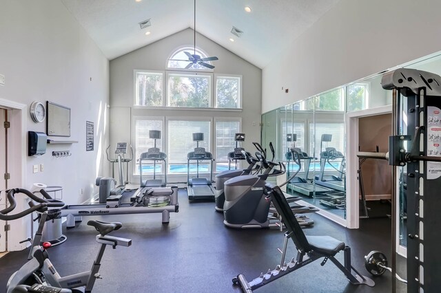 exercise room with ceiling fan and high vaulted ceiling