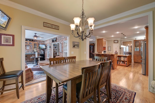 101 Firestone Ct, Summerville, SC 29483 - dining room featuring light wood-style floors, a chandelier, ornamental molding, and a ceiling fan