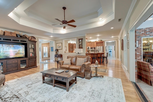 101 Firestone Ct, Summerville, SC 29483 - living room featuring ornamental molding, a ceiling fan, a raised ceiling, light wood finished floors, and a chandelier
