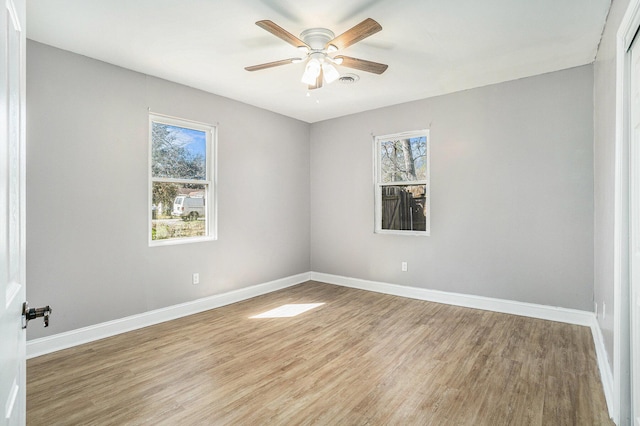 empty room with ceiling fan, baseboards, and wood finished floors