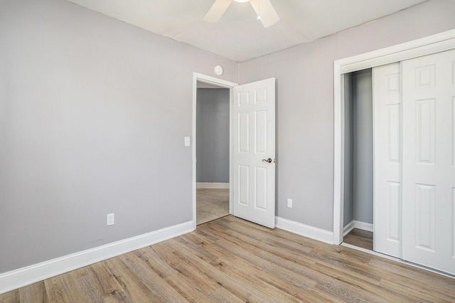 unfurnished bedroom with light wood-style floors, a closet, ceiling fan, and baseboards