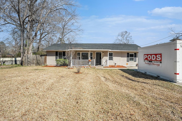 view of front facade with covered porch, roof with shingles, fence, and a front lawn