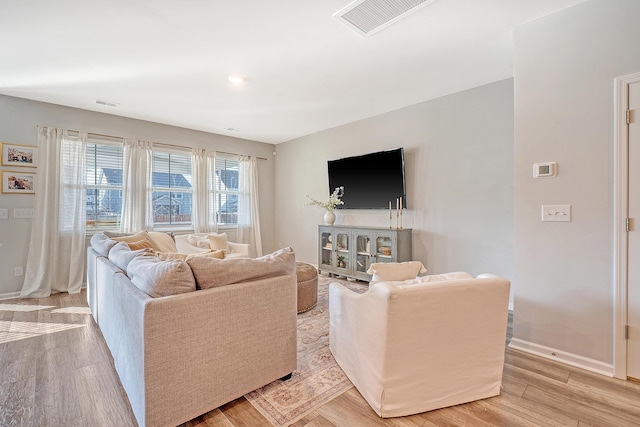 living room featuring baseboards, visible vents, and light wood-style floors