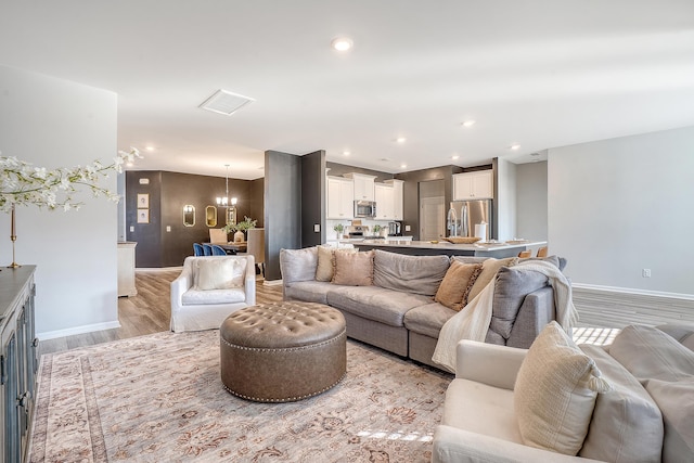 living room with a chandelier, recessed lighting, visible vents, baseboards, and light wood-type flooring