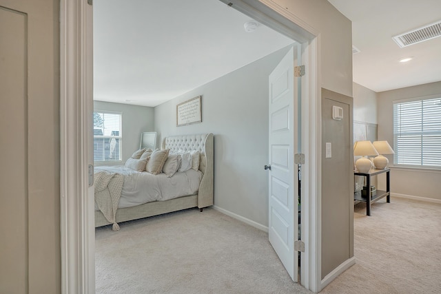 carpeted bedroom with visible vents and baseboards