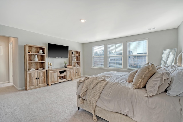 bedroom featuring baseboards, visible vents, and light colored carpet