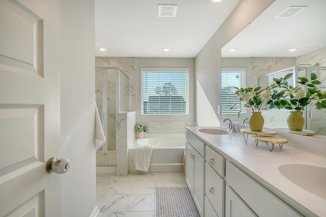 bathroom with a bath, marble finish floor, a shower stall, and a sink