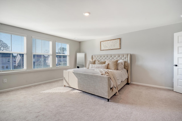 bedroom featuring light carpet and baseboards