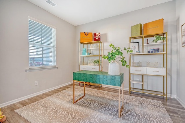 office area featuring baseboards, visible vents, and wood finished floors