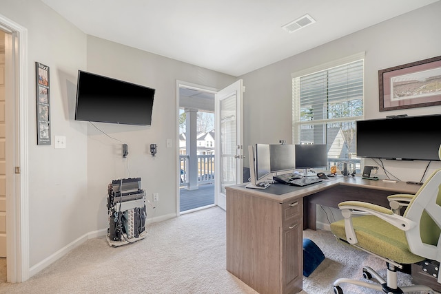 home office with a wealth of natural light, baseboards, visible vents, and carpet