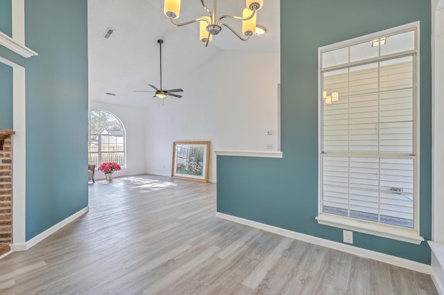 interior space with high vaulted ceiling, ceiling fan with notable chandelier, and light hardwood / wood-style floors