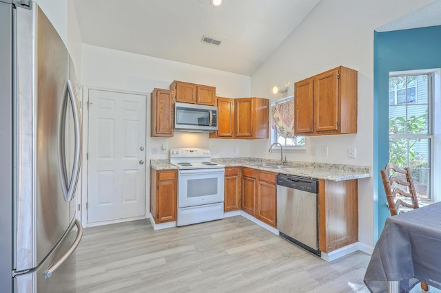 kitchen featuring light hardwood / wood-style flooring, sink, vaulted ceiling, and appliances with stainless steel finishes