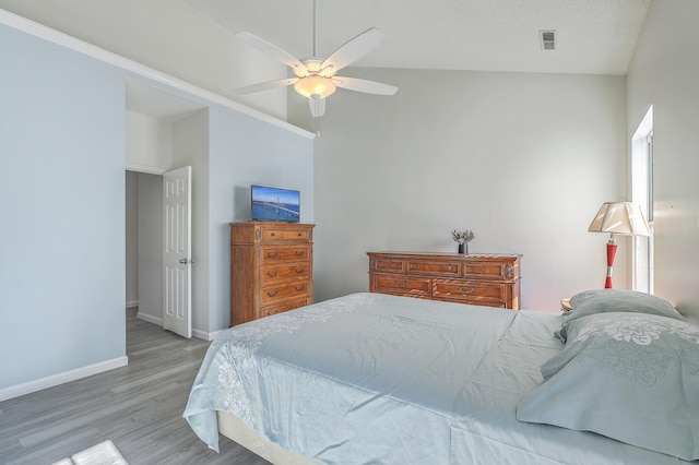 bedroom with ceiling fan, light hardwood / wood-style flooring, and a textured ceiling