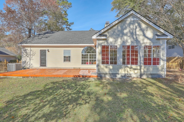 back of property featuring a deck, central air condition unit, and a lawn