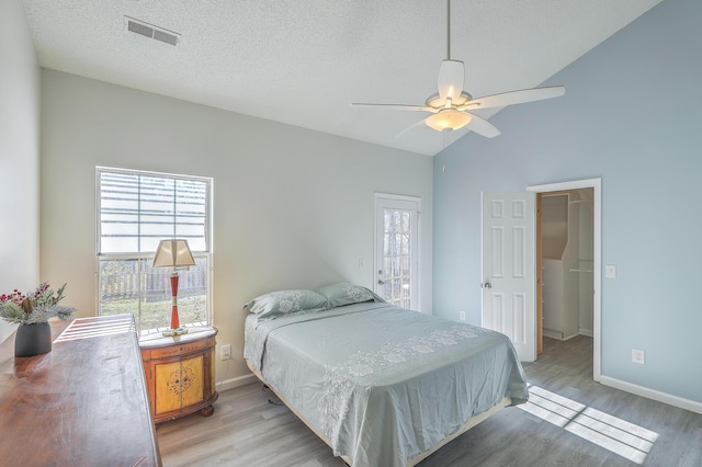 bedroom featuring multiple windows, lofted ceiling, and light hardwood / wood-style floors