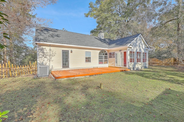 rear view of property with central AC, a deck, and a lawn