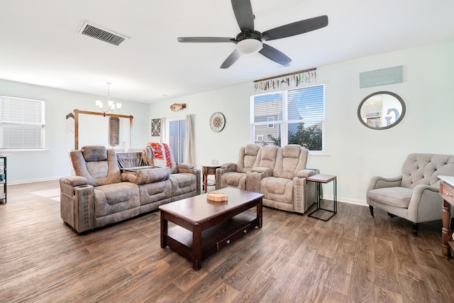 living room with ceiling fan with notable chandelier and hardwood / wood-style flooring