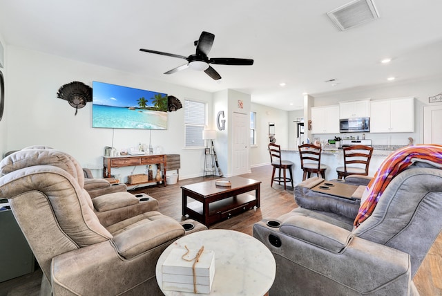 living room with hardwood / wood-style floors and ceiling fan