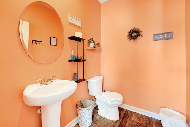 bathroom featuring toilet and wood-type flooring