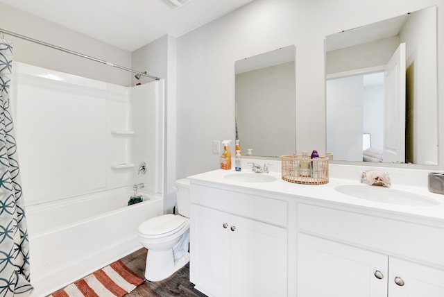 full bathroom featuring hardwood / wood-style floors, vanity, shower / tub combo, and toilet