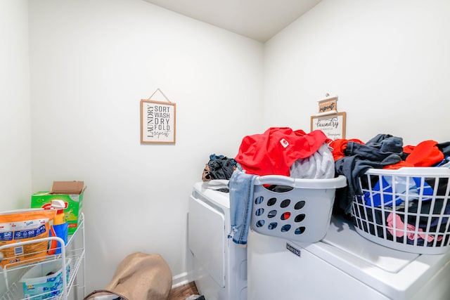 clothes washing area with hardwood / wood-style flooring and washing machine and dryer