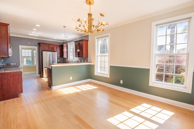 kitchen with freestanding refrigerator, baseboards, and a notable chandelier
