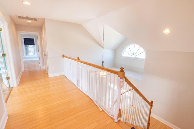 hall with recessed lighting, baseboards, an upstairs landing, light wood-type flooring, and visible vents