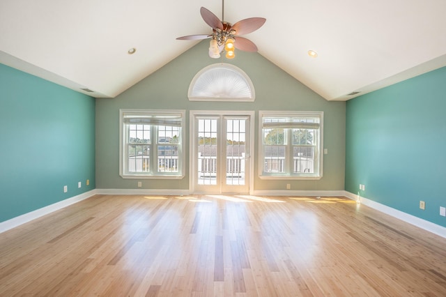 unfurnished room with light wood-style floors, high vaulted ceiling, a ceiling fan, baseboards, and visible vents