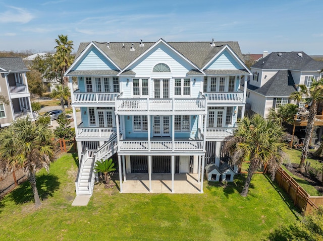 rear view of property with a lawn, a patio, and a balcony